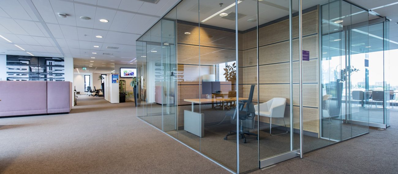 Modern kantoor met glazen vergaderruimtes en open werkplekken.