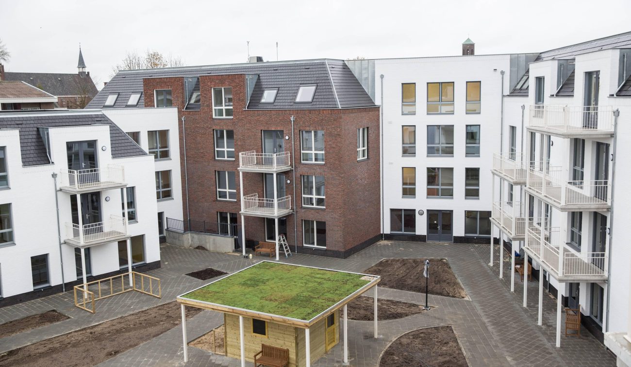 Hof te Berkel Horst – binnentuin met sedumdak-paviljoen, paden en appartementengebouwen met witte gevels en balkons