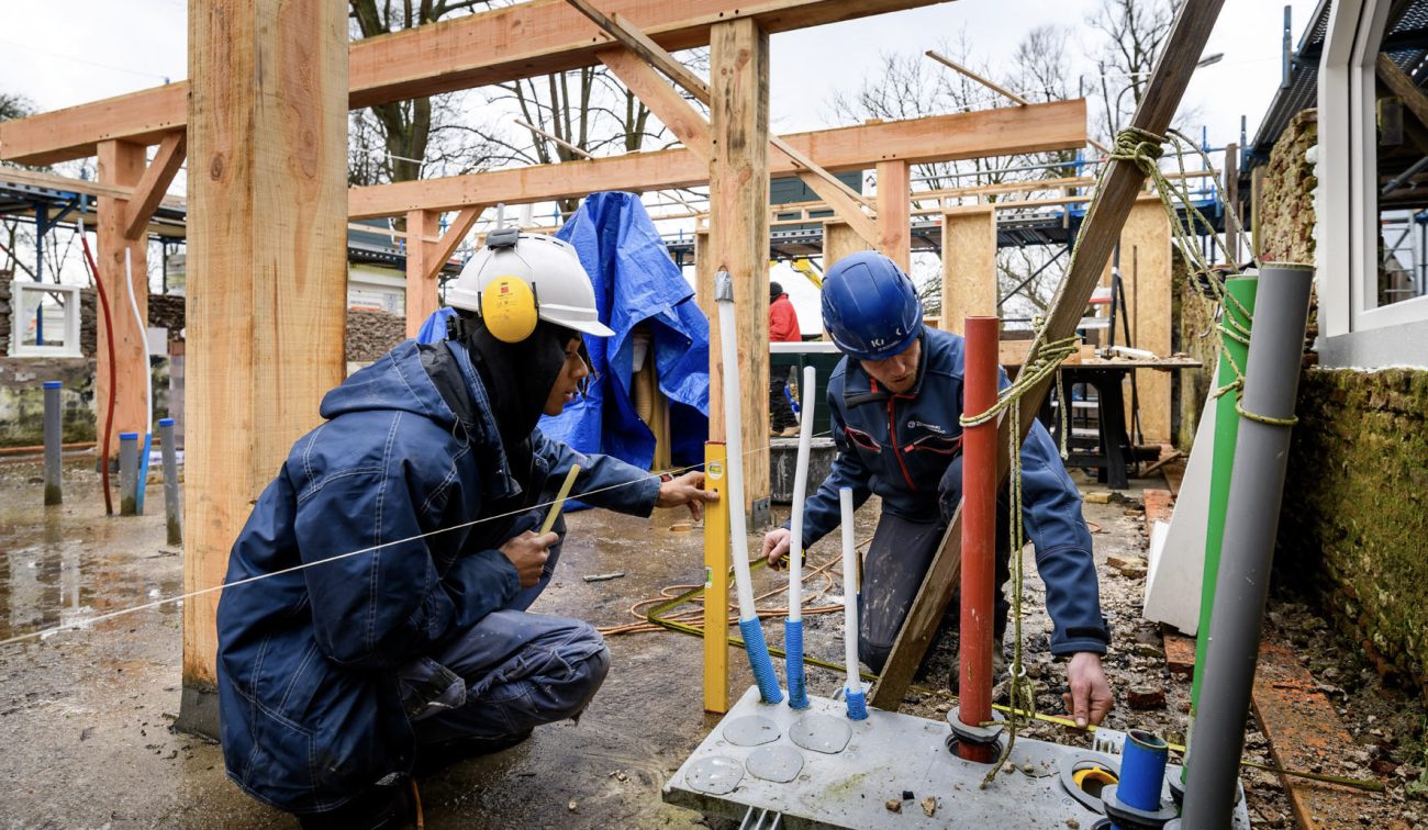 Restauratie Naardermeer: monteurs met helm werken aan installaties tussen nieuwe balkconstructie