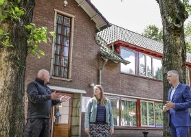 Renovatie Huis ter Heide: bakstenen paviljoen met rode kozijnen, dakpannen en overleg op de stoep