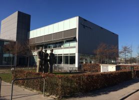 Voormalig kantoor omgebouwd tot Wellantcollege Rotterdam met strakke gevel en beeldengroep