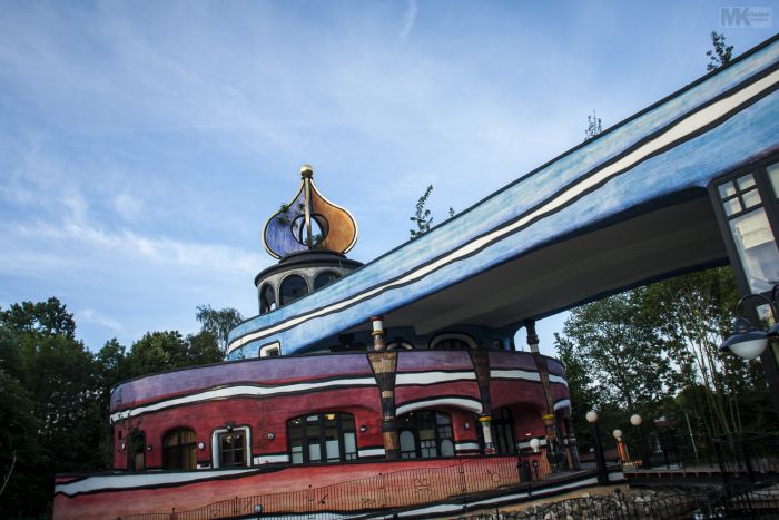 Ronald McDonald Kindervallei in Valkenburg met goudkleurige ui-koepel, golvend blauw dak en kleurrijke organische gevel met bogen en zuilen