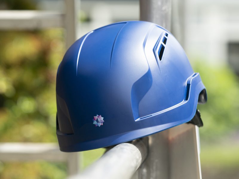 VB Groep logo op blauwe bouwhelm op een stijger