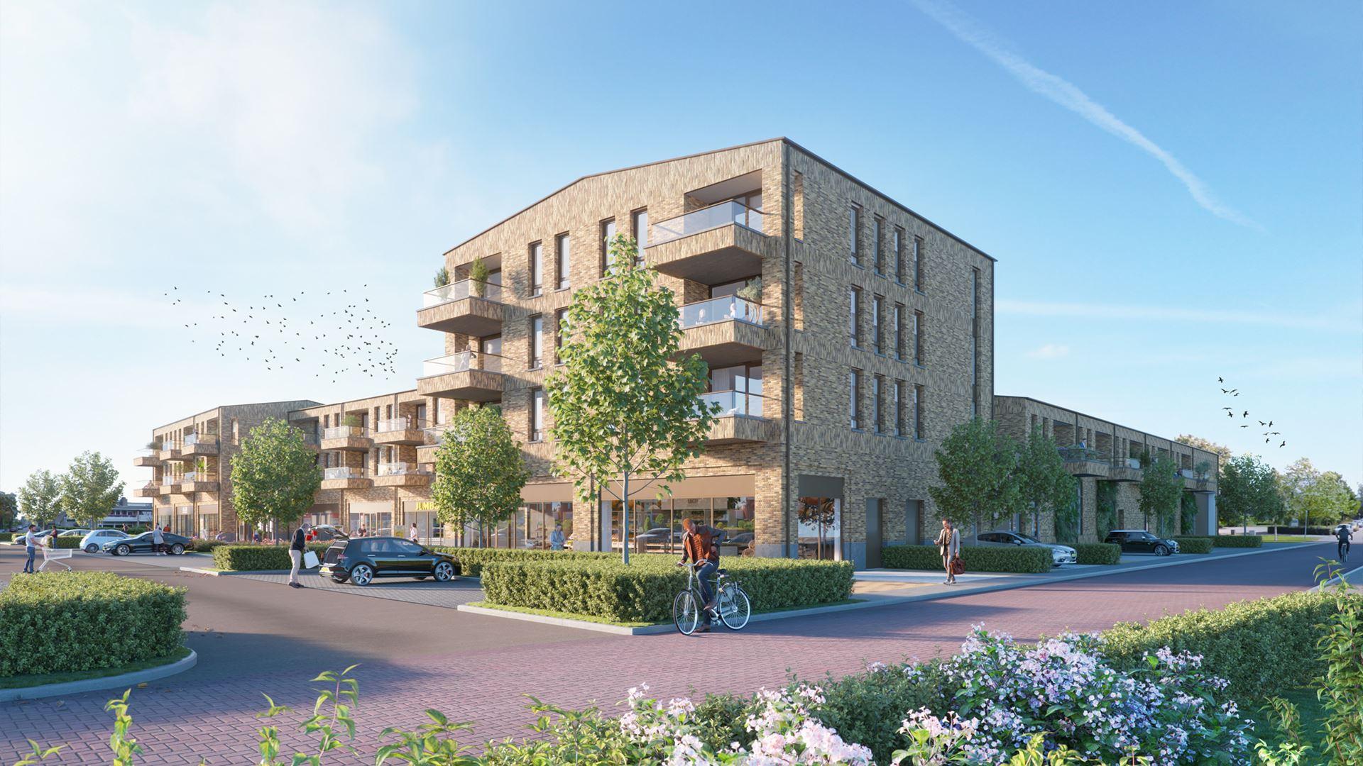 Impressie van appartementencomplex met bakstenen gevels, ruime balkons en winkels aan straatzijde