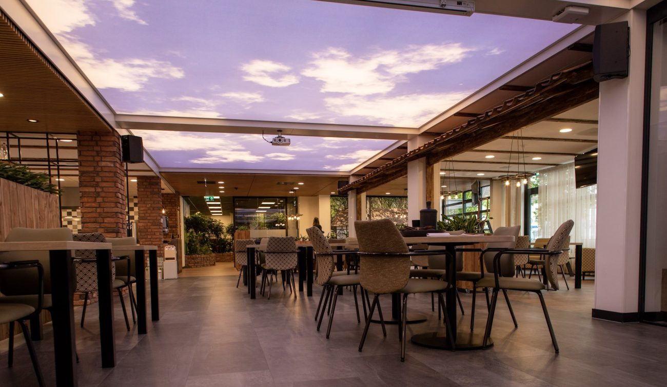 Interieur Aan de Bleek: huiskamer met sky-ceiling, houten accenten, baksteen en veel groen