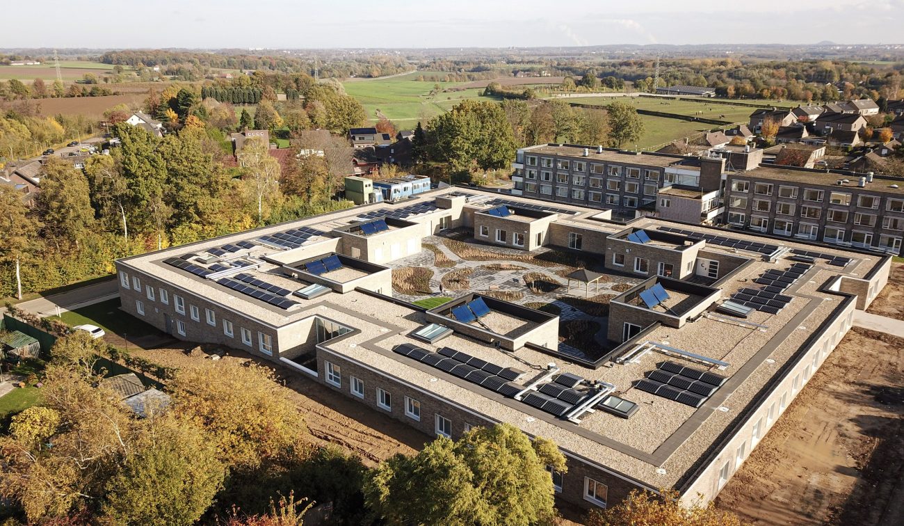Luchtfoto verpleeghuis Panhuys Hulsberg met plat dak vol zonnepanelen en binnentuin.