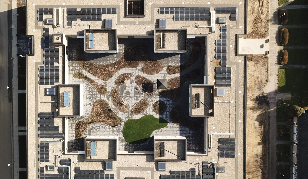 Recht-van-boven luchtfoto verpleeghuis Panhuys Hulsberg met zonnepanelen en centrale binnentuin.