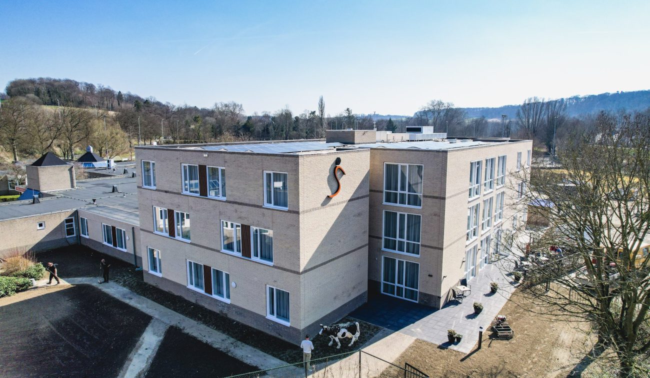 Zorgcomplex Valkenburg, moderne blok met lichte baksteen, paden en terrassen aan gevel.