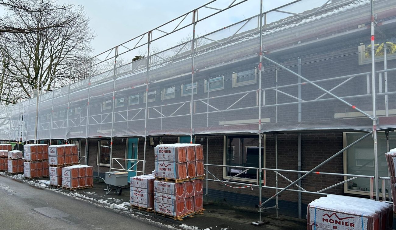 Groot onderhoud Berkdijk Tilburg: rijwoningen in steigerdoek, pallets dakpannen, winterse straat. nu