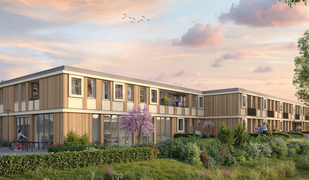 Woningbouw met houten gevels en grote raampartijen aan groen landschap met bomen