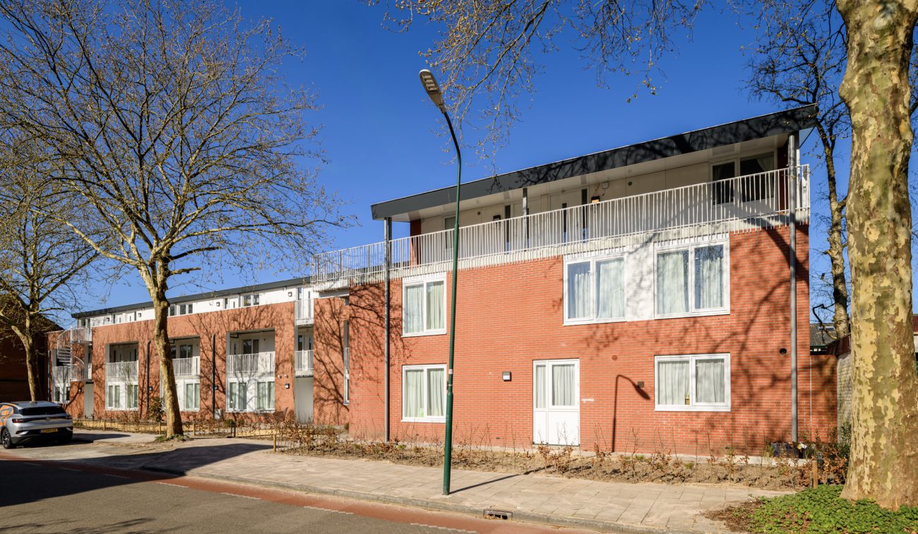 Vooraanzicht van wooncomplet met aanbouw van extra studio's op de bovenste verdieping