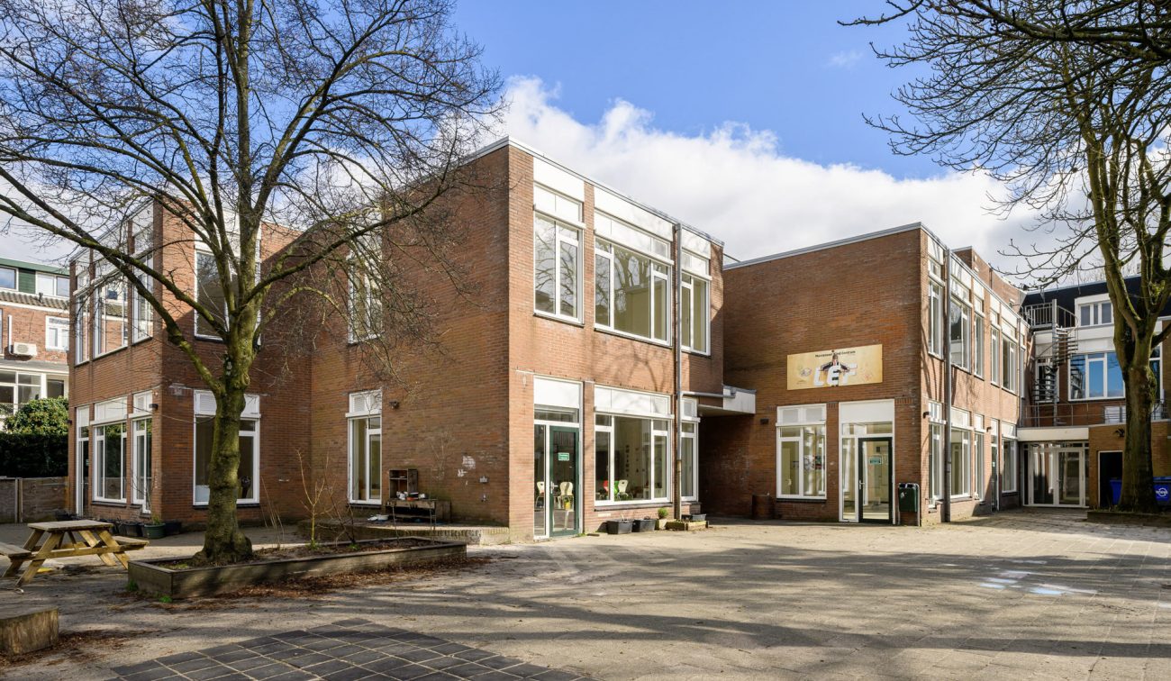Renovatie Kindcentrum LEF Utrecht – opgefrist schoolcomplex met vernieuwde entrees en puien, behoud van bakstenen gevels en veel daglicht aan het centrale schoolplein.