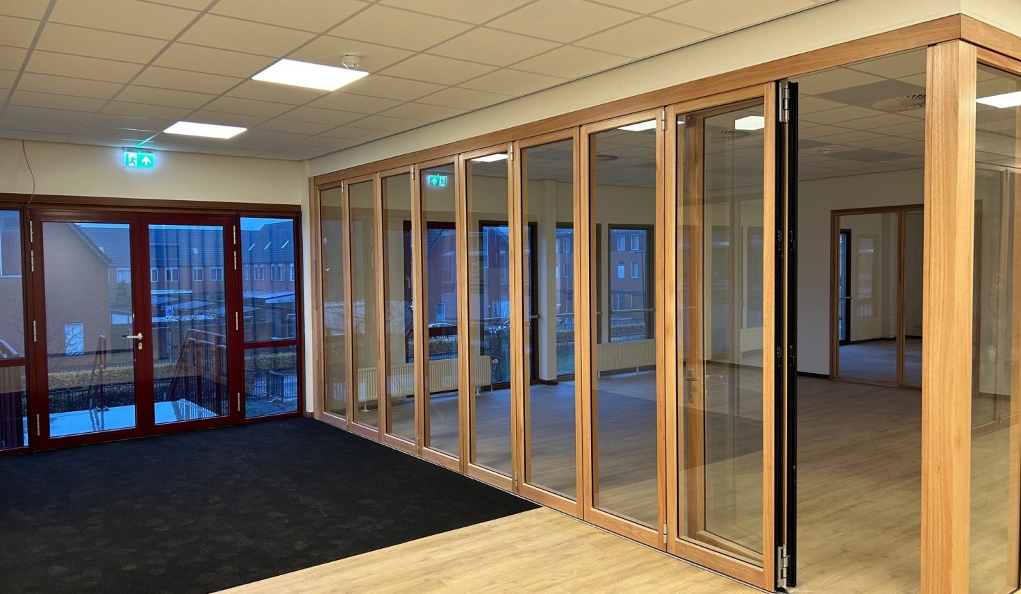 Glazen wand in een leslokaal en de ingang naar de binnenplaats in een schoolgebouw