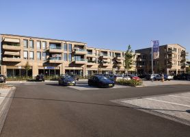 Nieuwbouw De Scheperij Teteringen: appartementen met balkons boven winkels, baksteen en parkeerplein