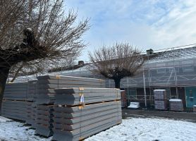 Groot onderhoud Berkdijk Tilburg: steigers bij rijhuizen, stapels dakplaten, sneeuwdek en knotbomen.